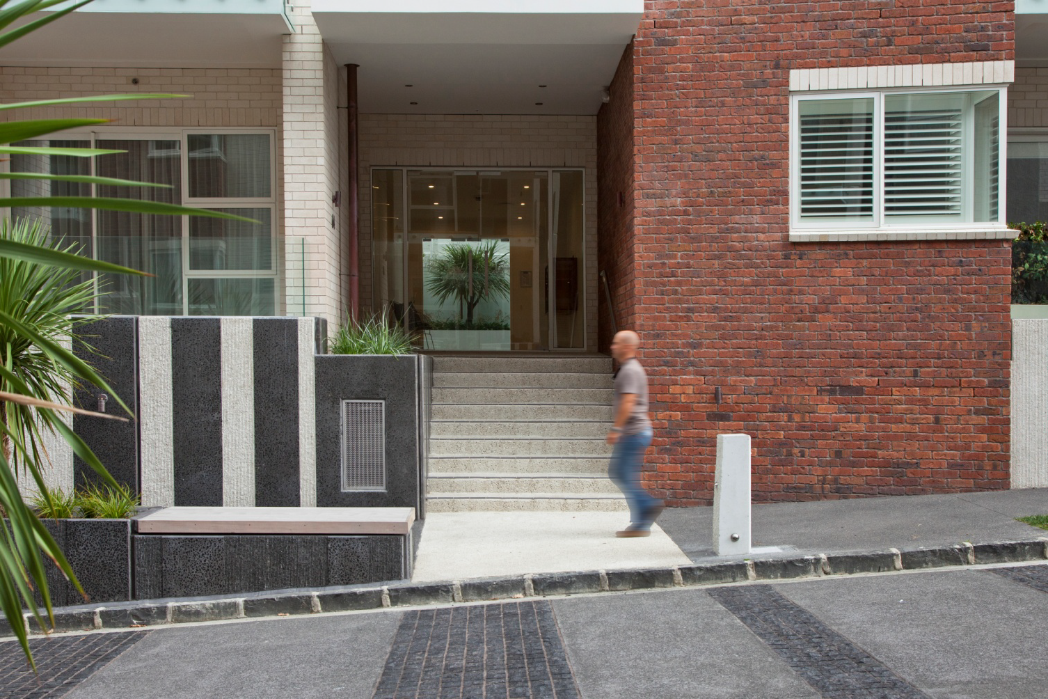 Looking into a lobby from the street, a man is walking past.