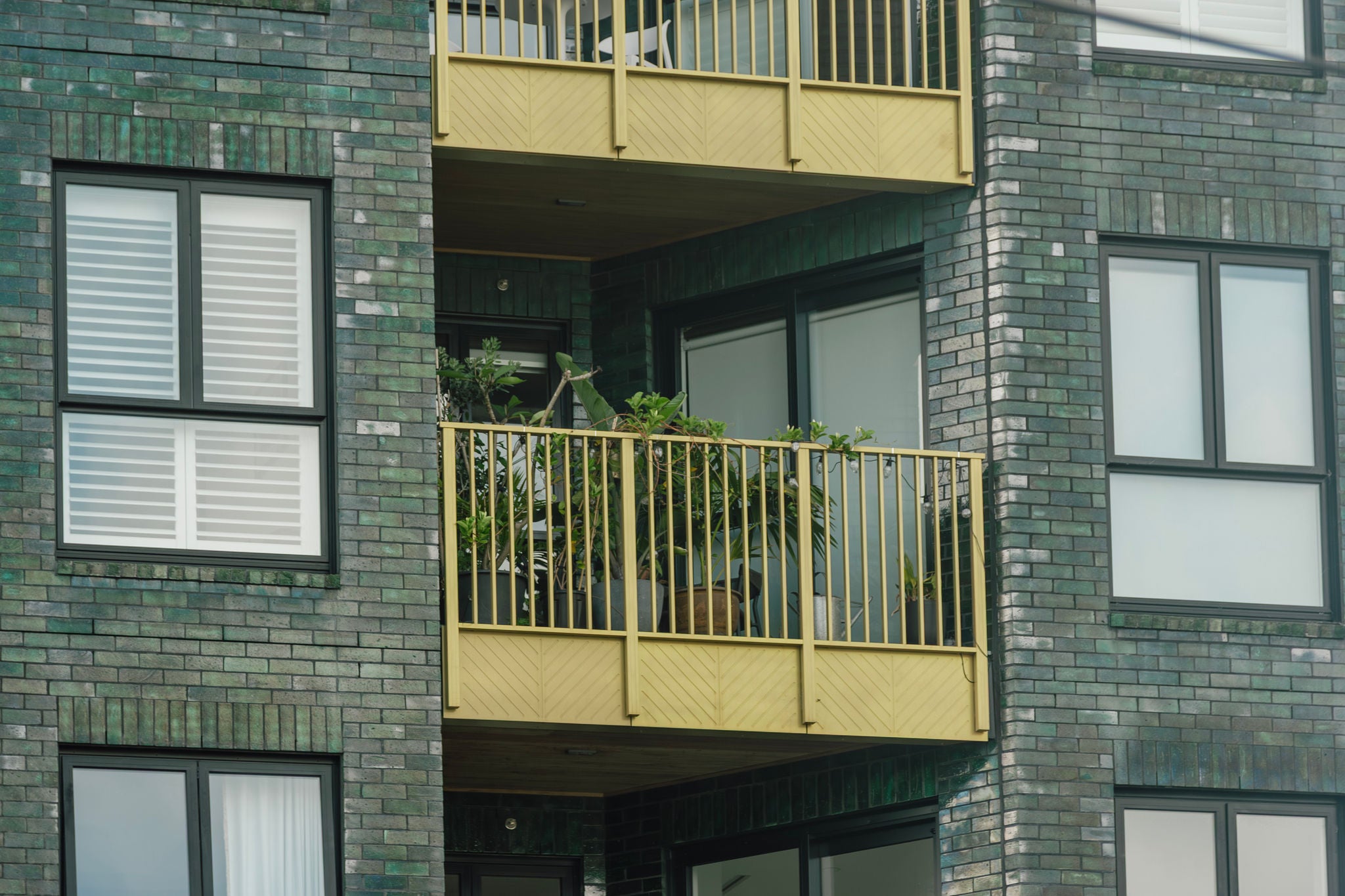 Snapshot of the upper balconies, showing potted plants and outdoor seating.