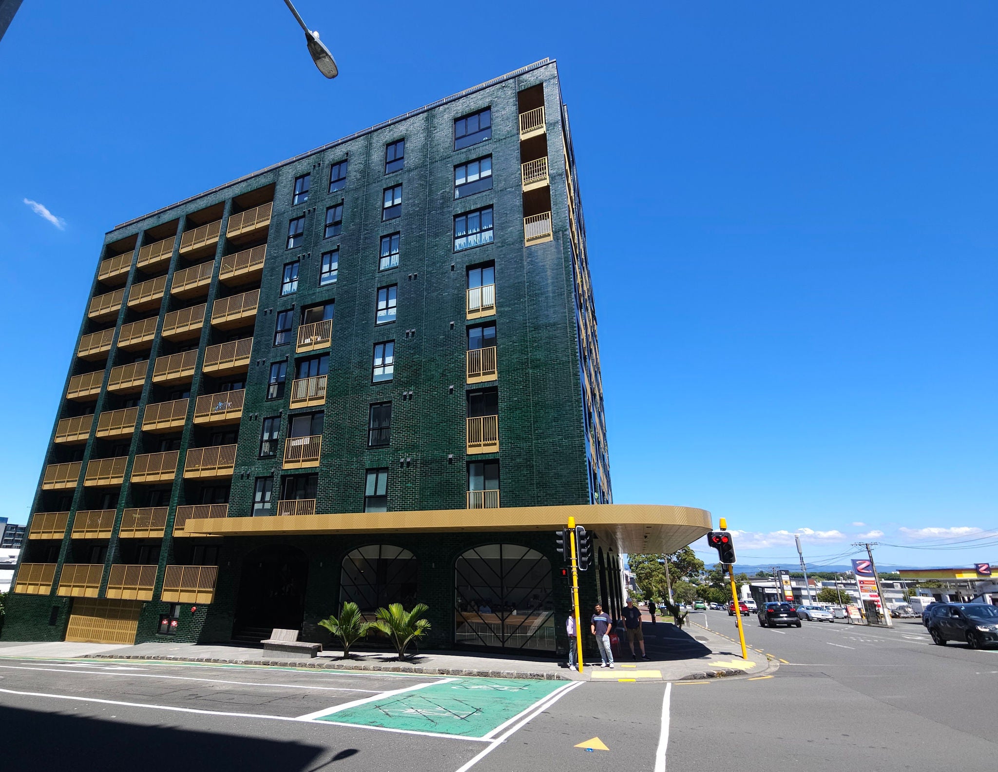 Looking down the street, at the Greenhouse with its lush green and  gold facade.
