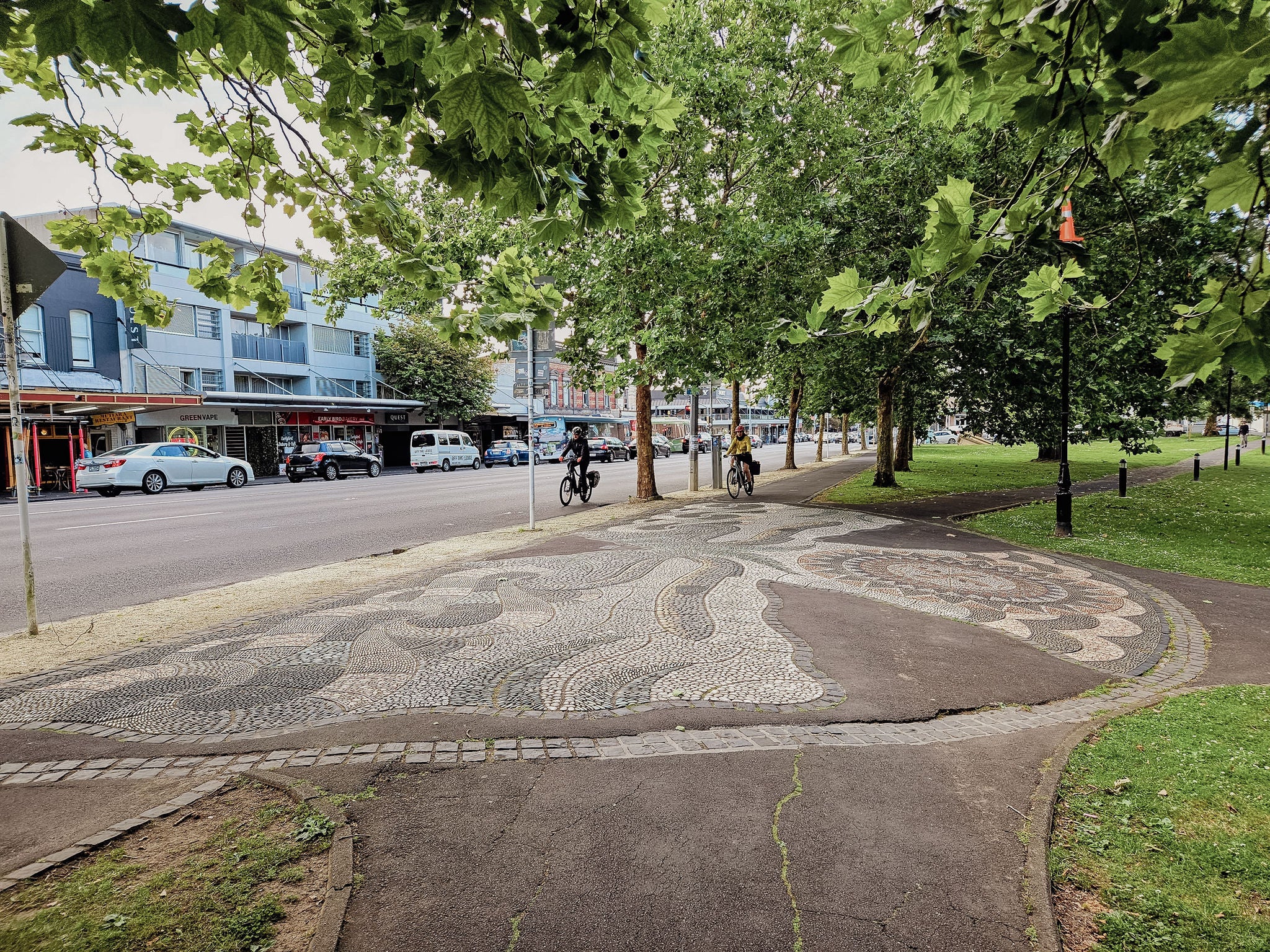 Western park on a sunny day, as seen from Ponsonby Road, with mosaic stone inlay. on the path