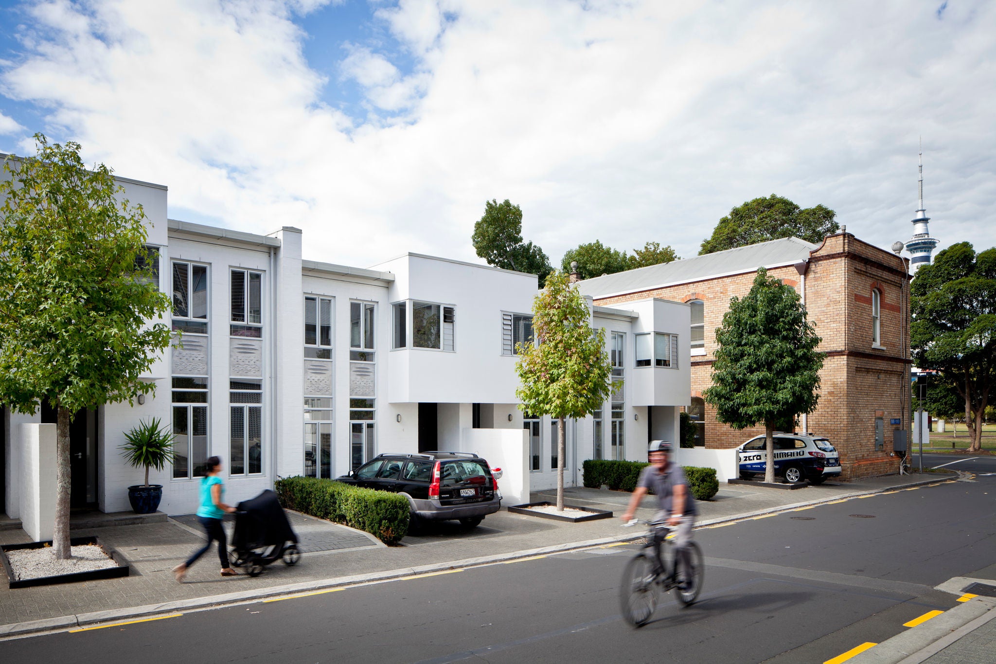 A cyclist rides past the entrance and façade of the development from Beaumont street.
