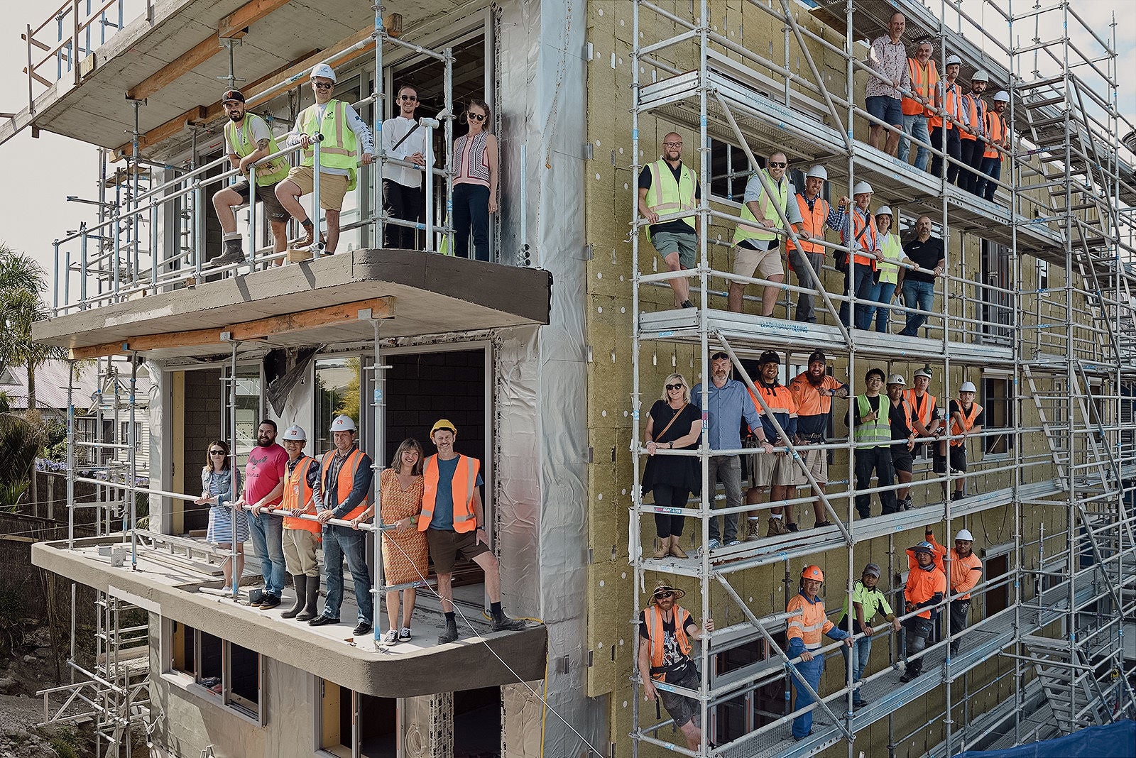 Builders and owners standing on the scaffolding around the building while in progress.