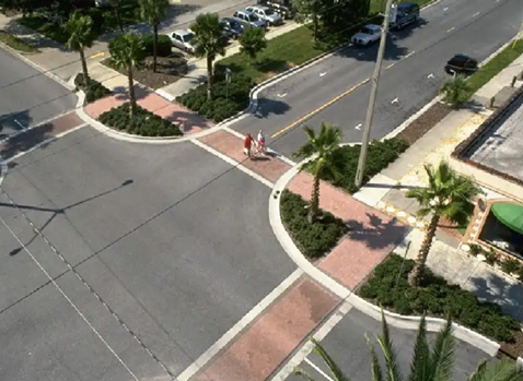The intersection corners are enlarged and attractively enhanced while tightening the street to slow vehicles.