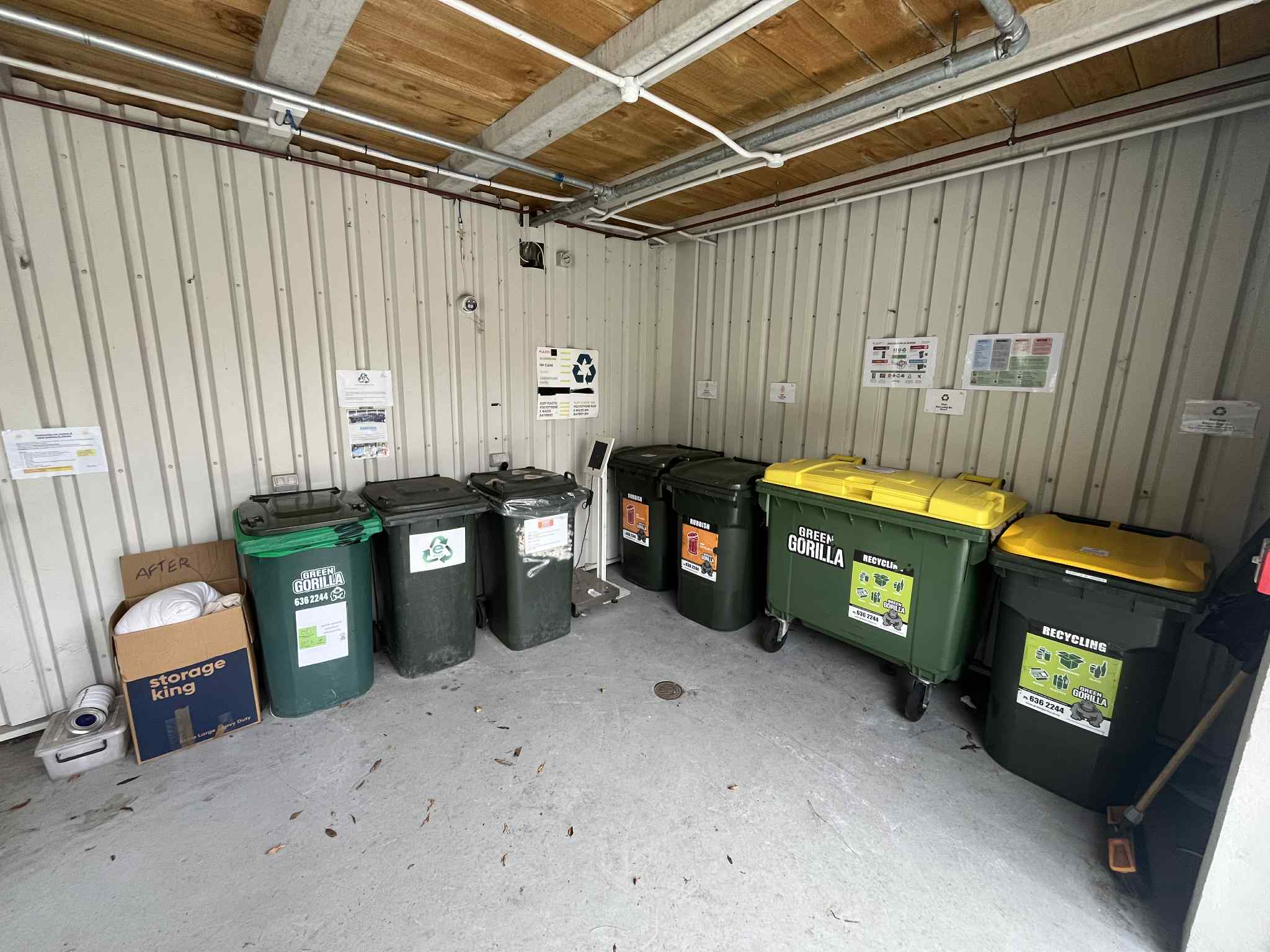 A photo of a storgae room with nine waste bins.