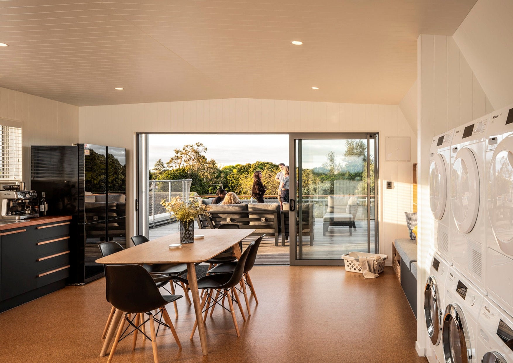 Showcasing shared laundry facilities as well as kitchen and dining