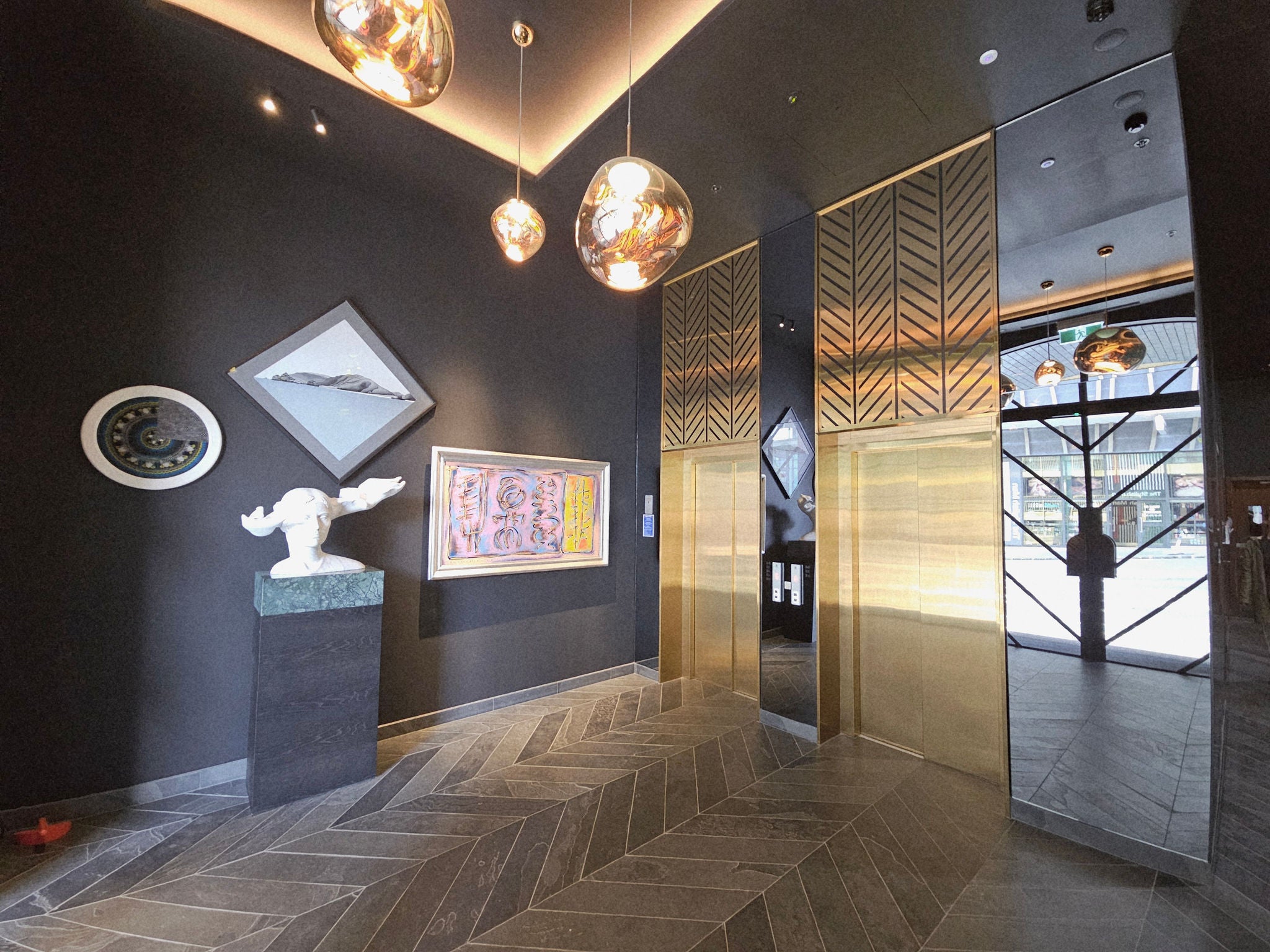 Inside the Pollen St entrance looking at the gold coloured lifts and beautiful artworks.