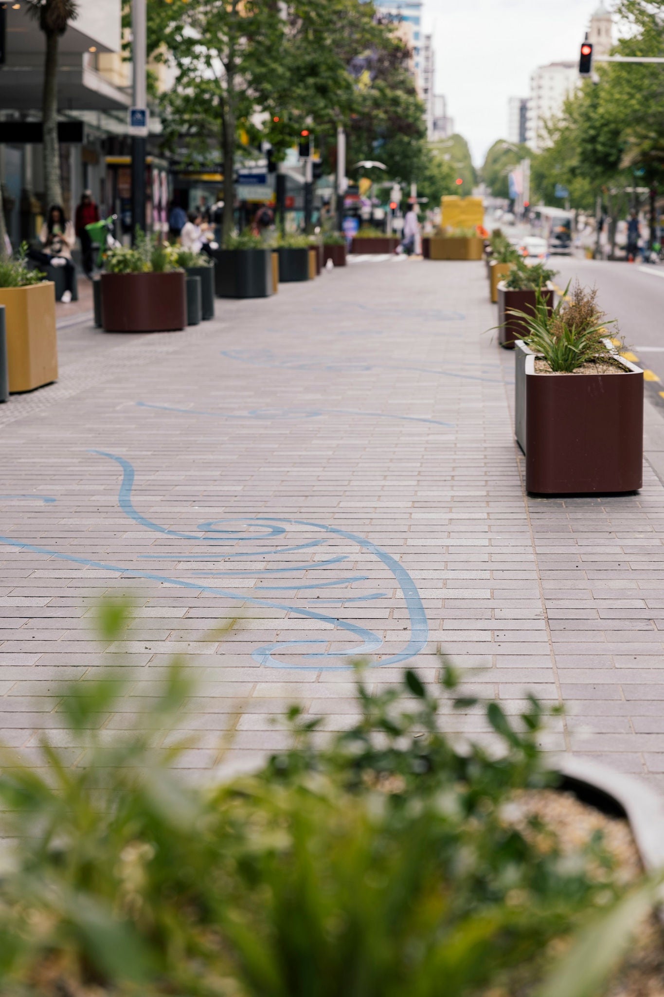 The paved Waihorotiu Path with cultural ground graphics and steel planters.
