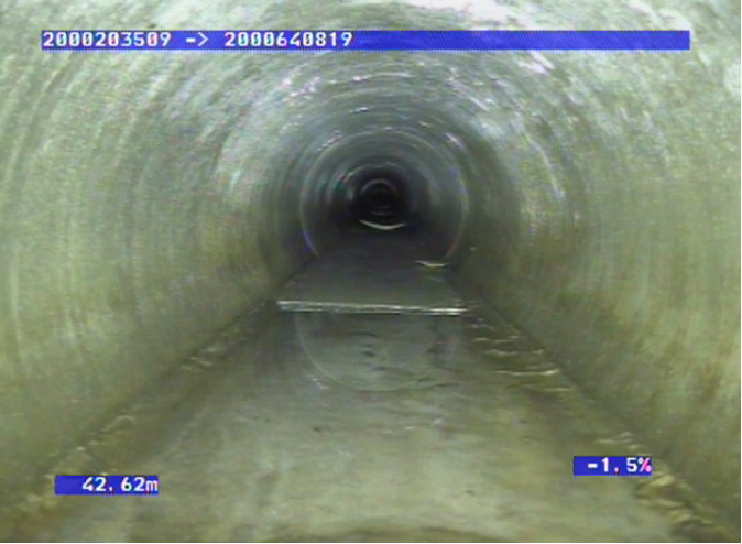 Looking at the concrete blockage inside the pipe through a scope.
