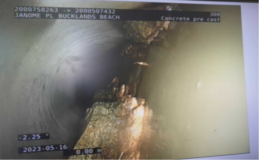 Looking at the concrete blockage inside the pipe through a scope.