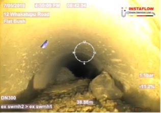 Looking at the concrete blockage inside the pipe through a scope.