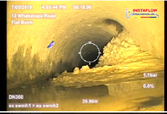 Looking at the concrete blockage inside the pipe through a scope.