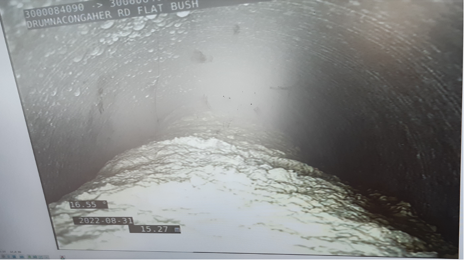 Looking at the concrete blockage inside the pipe through a scope.